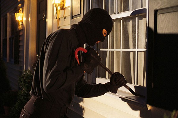 burglar-trying-to-pry-open-window-on-house-pic-getty-images-123608196